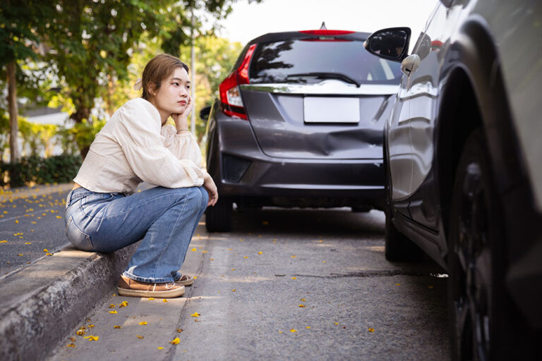 Frustrated female driver waiting by the road after car accident.