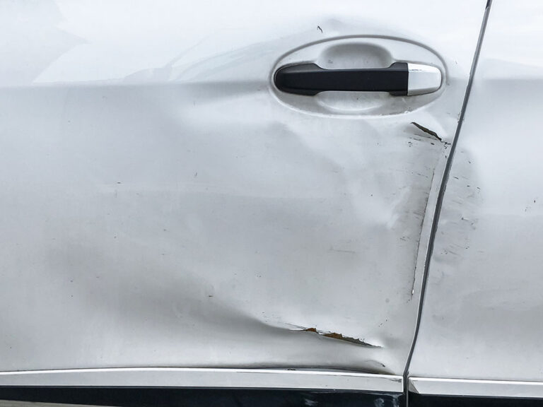 Dents on the car door caused by the accident. scratched car body.