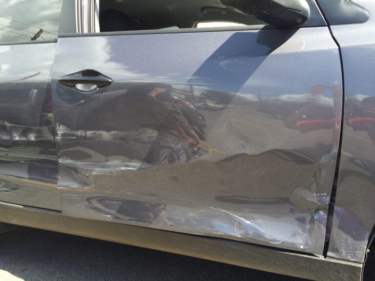 Accident Damage on Side of Gray Car in Parking Lot. High quality photo